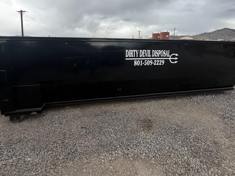 Black 30 yard roll-off dumpster with the Dirty Devil Disposal logo and phone number