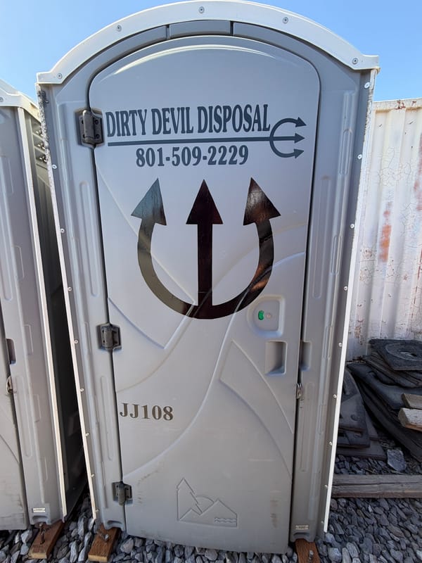 Dirty Devil Disposal porta potty with the pitchfork logo on the door